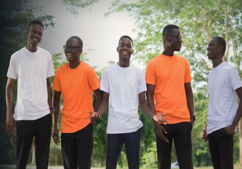 Corporate team members in plain orange and white shirts smiling outdoors